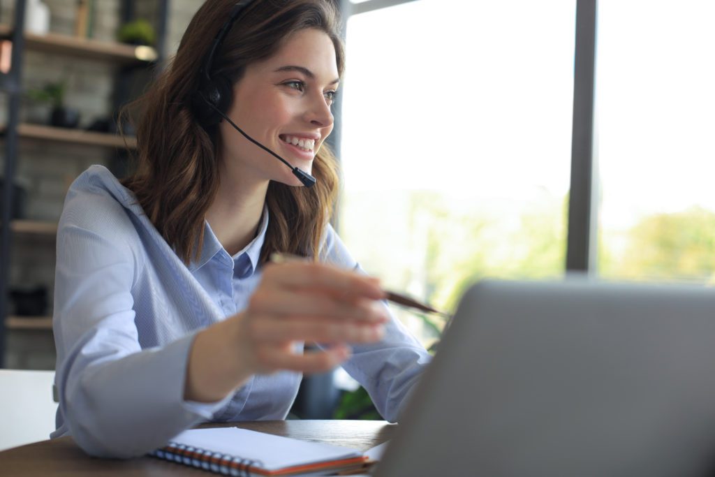 Enrollment Counselor talking with headset and consulting clients from home office